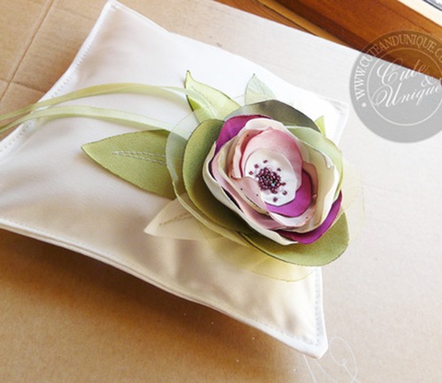white ring bearer pillow with purple green floral accents
