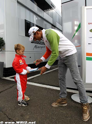 Адриан Сутиль дает автограф мальчику в комбезе Ferrari на Гран-при Бельгии 2010
