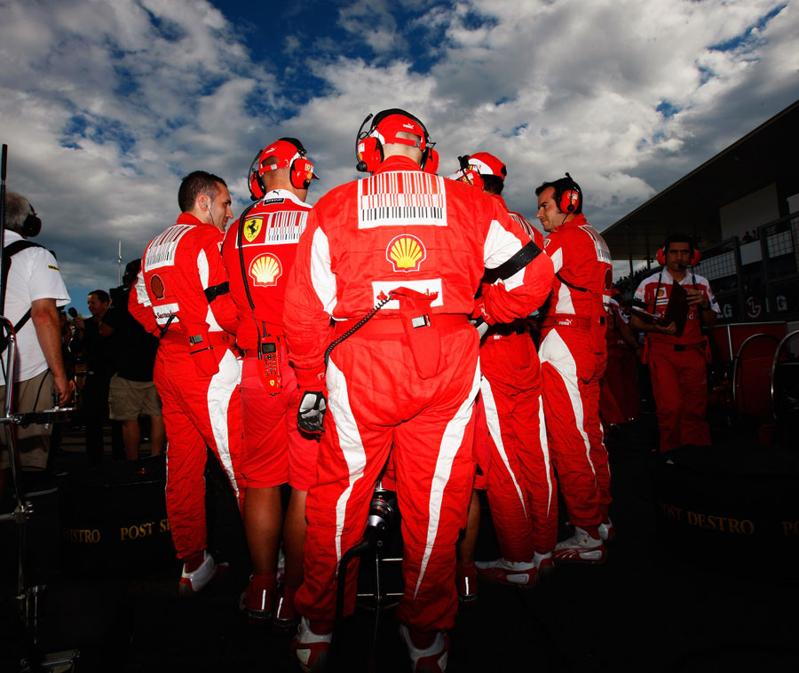 механики Ferrari охраняют свой болид на стартовой решетке Гран-при Японии 2010