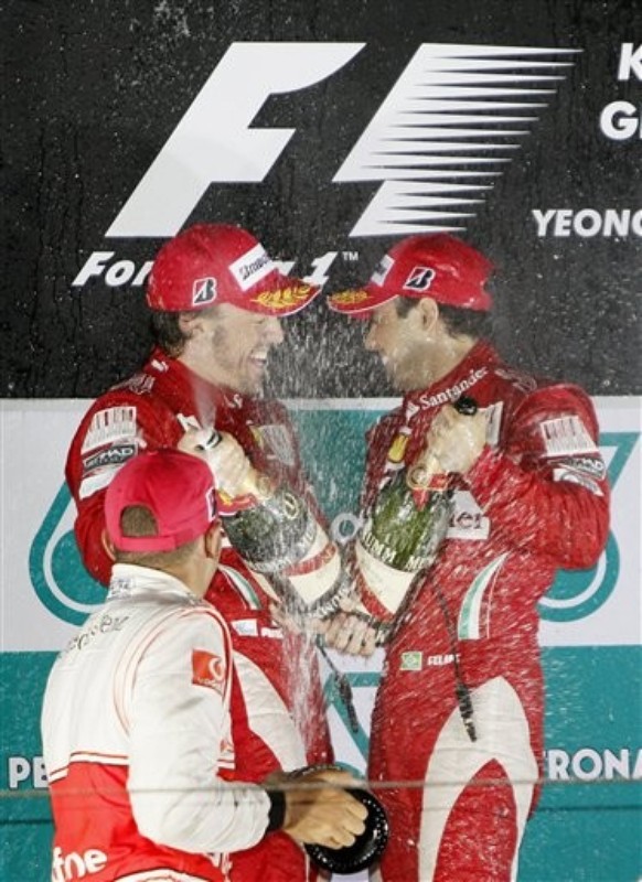 Фернандо Алонсо и Фелипе Масса на подиуме Гран-при Кореи 2010 брызгаются шампанским вместе с Льюисом Хэмилтоным