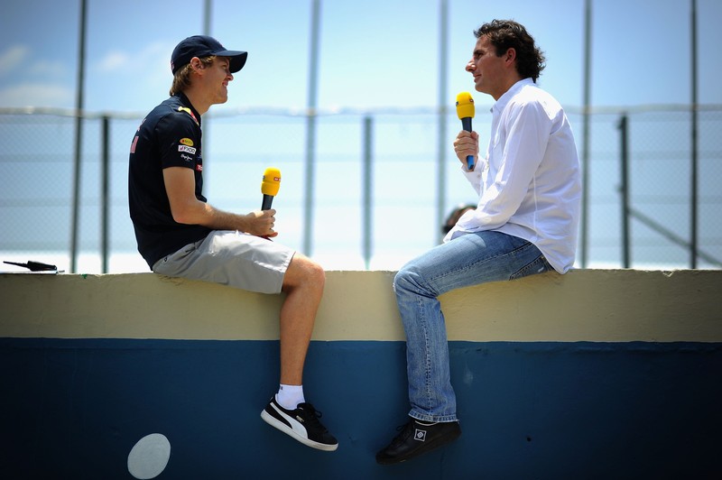 Себастьян Феттель дает интервью на бетонной стене автодрома Интерлагоса на Гран-при Бразилии 2010