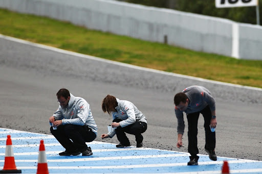 McLaren_staff_collect_tyre_marbles2_13feb2011.jpg