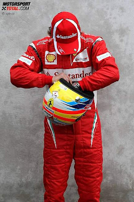 Фернандо Алонсо на фотосессии Гран-при Австралии 2011 ищет что-то в шлеме