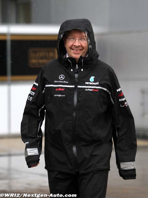 Росс Браун идет по дождливому паддоку Куала-Лумпура на Гран-при Малайзии 2011