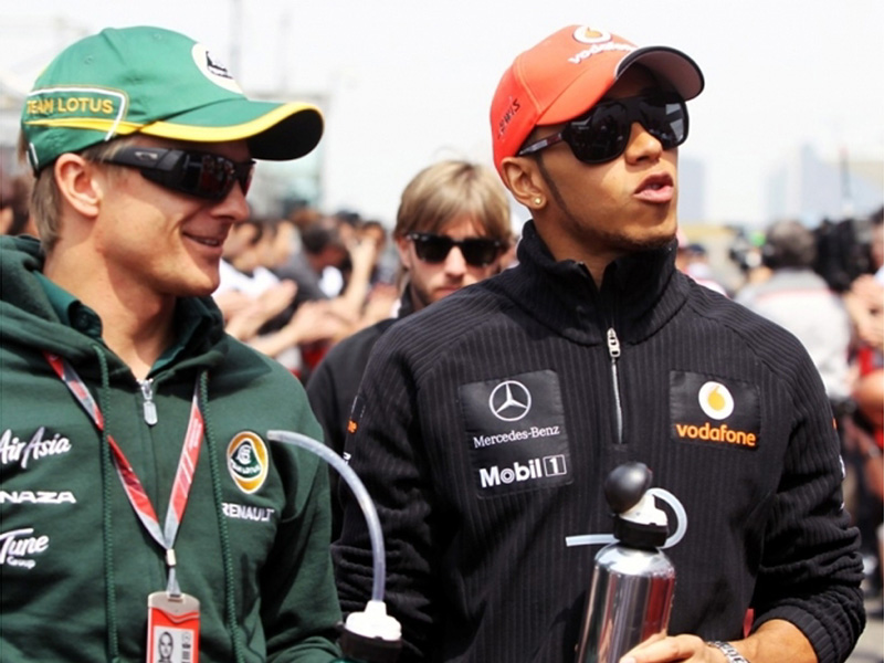 Хейкки Ковалайнен и Льюис Хэмилтон идут и разговаривают вместе на Гран-при Китая 2011