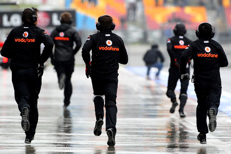 механики McLaren бегут по дождливому пит-лейну Истамбул-Парка на Гран-при Турции 2011