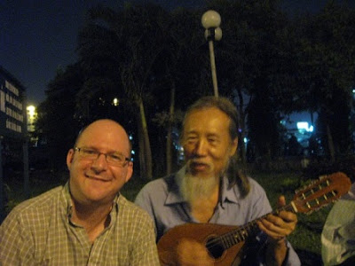 Dave Fox and a friendly mandolin player at a park in Saigon Dave Fox and a friendly mandolin player at a park in Saigon