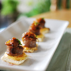 Grilled Bratwurst Appetizer with Dijon-Cheddar Fondue, Caramelized Onions, and Basil