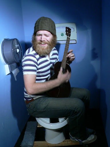 Me, playing ukelele in a fake bathroom stall.