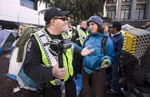 photo by Ben Naims, reuters
A citizen chastises a police officer for videotaping protestors. 