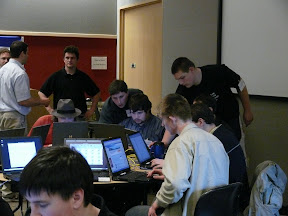 UW Tacoma team members gathered around laptops and discussing the situation, with Justin and Daniel suggesting what to look for