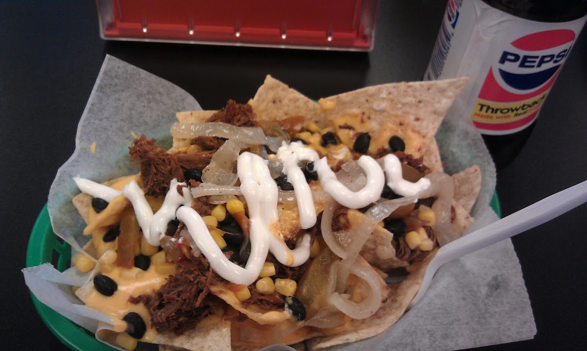 Nachos with shredded beef, black beans, corn, cheese, grilled onions, jalapenos, & sour cream!