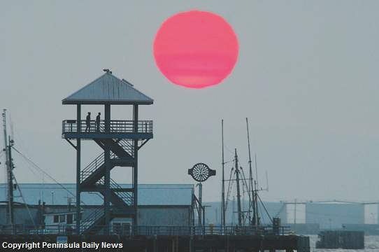 The sun sets behind Port Angeles City Pier Monday night, 9 July 2012. Smoke from wildfires in Siberia is producing spectacular sunsets. Keith Thorpe / Peninsula Daily News