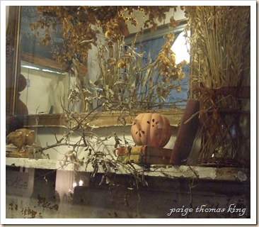 mantel with wheat, branches, bookd and pierced pumpkin
