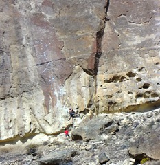 The guy in red is belaying the climber above.