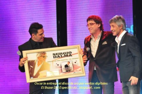 Oscar le entrega el disco de oro por ventas digitales.jpg