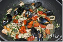Serpenyőben keszül a tengeri gyümölcsös ragu: fekete kagyló, garnéla, kalmár, apró polip sül egy fokhagymás, olajos, fehérboros alapban.