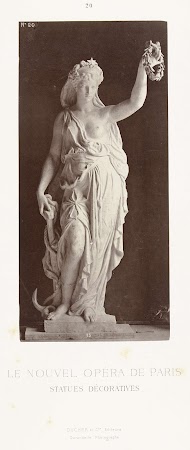 Marmeren beeld van een vrouw in een gewaad met een ontblote borst, in haar linkerhand draagt zij een lauwerkrans, in haar rechter een scheepsanker.