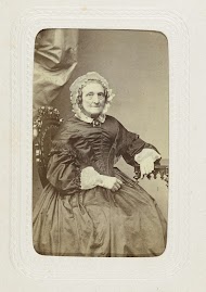 Studioportret van een oudere dame gekleed in een zwarte pofjurk