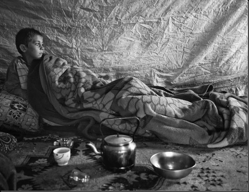 Faysal, 6, waking up inside his family's tent a settlement in the Bekaa Valley, Lebanon. (Moises Saman/Magnum Photos for Save the Children)