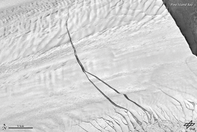 Aerial view of a crack in Pine Island Glacier, 14 September 2012. When the crack reaches the other side of the ice shelf, it will send a huge new iceberg drifting into Pine Island Bay. NASA Earth Observatory image by Robert Simmon with data from the German Aerospace Center