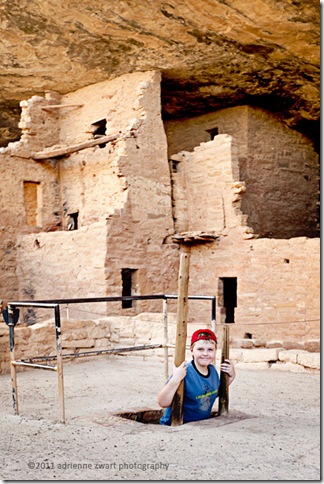 Exploring the Kiva boy on kiva ladder Mesa Verde - photo by Adrienne zwart