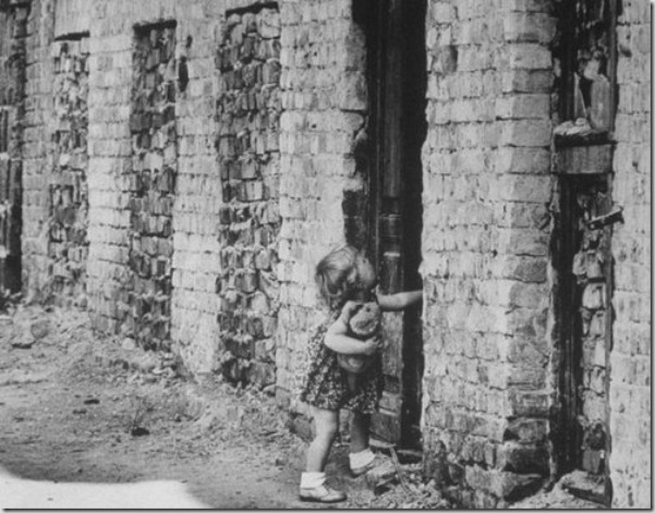 A West Berlin toddler attempts to open a sealed door of a house that has become part of the Berlin Wall in August 1961 via Paul Schutzer - Getty Images