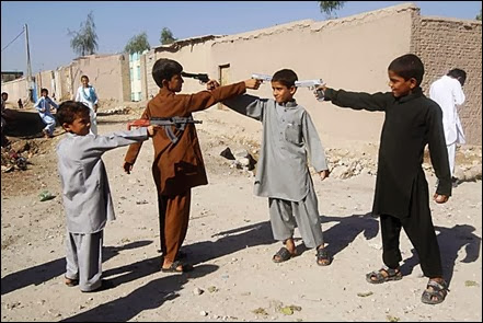 Crianças afegãs brincam com pistolas de imitação em Jalalabad