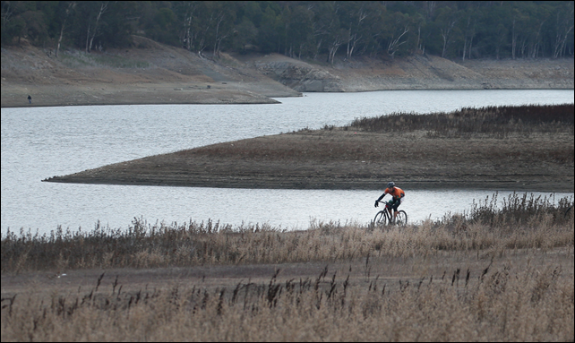 A bicyclist rides in an area that was previously underwater at Lexington Reservoir in Los Gatos Wednesday, 8 January 2014. Photo: Patrick Tehan / San Jose Mercury News