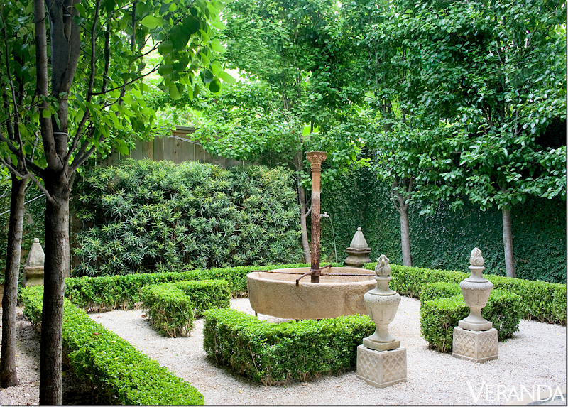 Jane Moore's Belgian inspired garden. All green with boxwood, ivy and shrubs only. The pear trees are planted in rows to impart an architectural feel to the space. A lovely outside room within a room? Antique fountain and two urns stand at the “door” to the outdoor room which has a ground of white gravel. Two obelisks stand at the corners of the garden. Landscape design by Glauser McNair. Photo by Peter Vitale for Veranda, March 2012. Found on Hello Lovely Studio.
