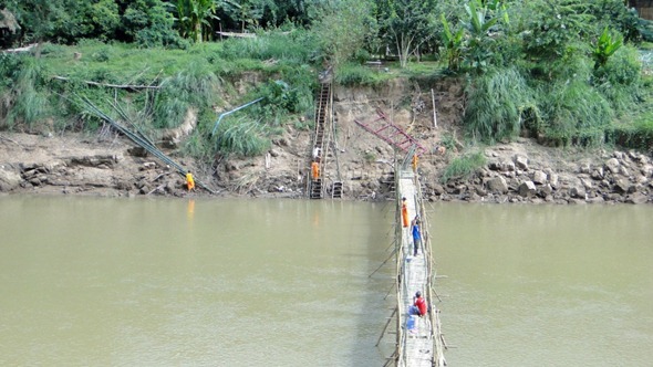 Monges ajudam na construção da ponte de bambu