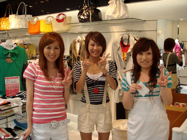 cute Japanese girls in a fashion store in Harajuku making peace signs in Harajuku, Japan 