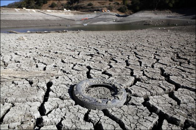 A discarded tire is seen stuck in the exposed lake bed of the Almaden Reservoir which is experiencing extremely low water levels due to the ongoing drought, in San Jose, 30 January 2014. Photo: Michael Short / The Chronicle