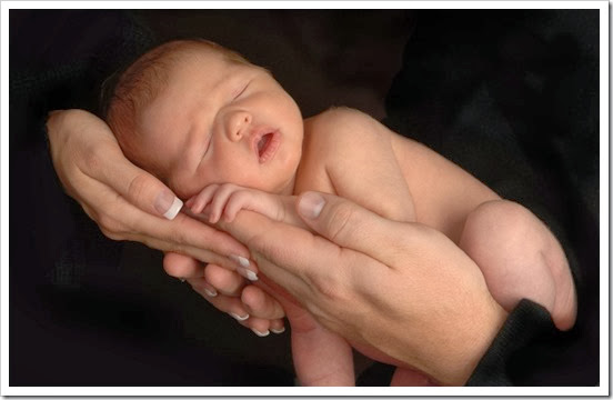 [wallcoo_com]_newborn_baby_Photo_A pair of hands holding a sleeping baby_ISPC006054