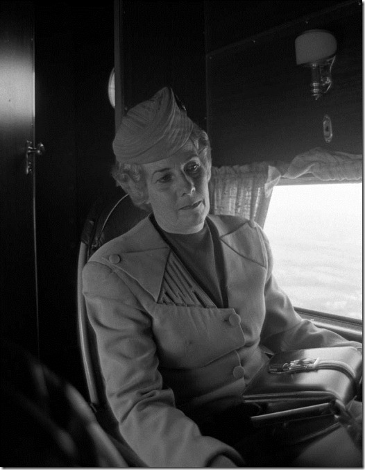 Flight attendant in a 1929 TAT stewardess uniform aboard a Ford Tri-Motor in the livery of Transcontinental Air Transport, the forerunner of Trans World Airlines, as it would have appeared at the inauguration of TWA's transcontinental passenger service in 1929. This aircraft toured the U.S. for the 45th anniversary of TWA's transcontinental service in 1974. The plane is now housed at the McMinnville, Ore., airport and flies at airshows. This photo was made at Weir Cook (now Indianapolis International) Airport.