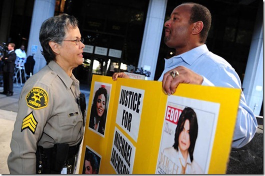 A sheriff's deputy (L) talks to Michael Jackson Najee outside Superior Court in downtown Los Angeles, September 8, 2011 where jury select begins today in the trial of Jackson's former physician Dr Conrad Murray.  Murray is charged with a felony count of involuntary manslaughter stemming from Jackson's death two years ago at age 50 from propofol intoxication.  AFP PHOTO / ROBYN BECK (Photo credit should read ROBYN BECK/AFP/Getty Images)
