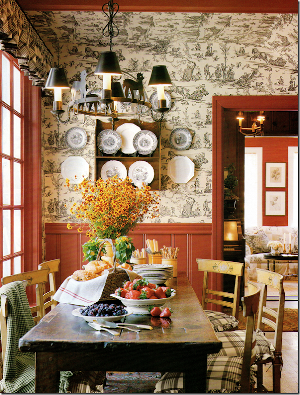 Jane Moore's breakfast room has a charming black and white toile mixed with red paneling. Rustic table, more transferware mixed with creamware.