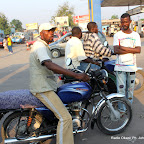 Marché Bayaka de Ngiri-Ngiri.  Ce motard hèle les passagers. Eh oui, vous avez bien lu : à Kinshasa, les passagers ne hèlent pas les taxi-motards. C’est plutôt l’inverse qui se fait.