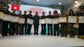 Đại tá Tạ Đức Thanh (Đoàn trưởng Đoàn 338, đứng giữa) trao huy hiệu cho các cán bộ, chiến sỹ Đại tá Tạ Đức Thanh (Đoàn trưởng Đoàn 338, đứng giữa) trao huy hiệu cho các cán bộ, chiến sỹ