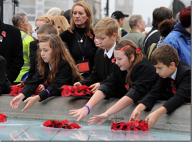 Children-place-poppies-in Trafalgar Square fountain