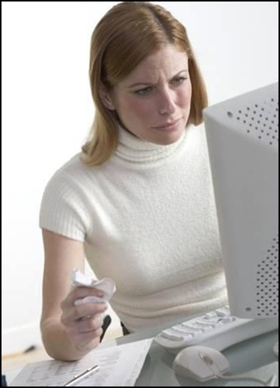 Distressed_woman_at_desk_with_computer_u12405199