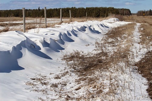 Snow drifts along the road