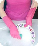Woman in pink rubber gloves washing dishes Woman in pink rubber gloves washing dishes
