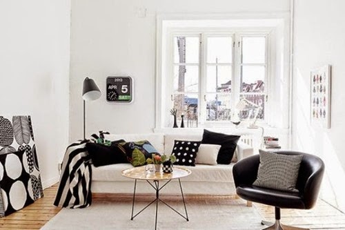 wooden-floor-floor-lamp-grey-rug-black-arm-chair-glass-window-white-sofa-with-cushions-duvet-rounded-coffee-table-ornaments