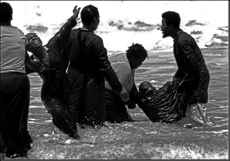 SOUTH AFRICA. Natal. Durban. Members of a religious group participating in a total immersion baptism ceremony in the Indian Ocean. 1984.