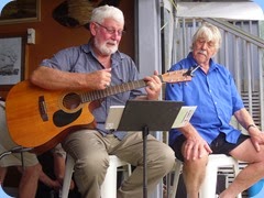 Member, Peter Wilton on guitar and fellow vocalist, Jeffrey, singing along.