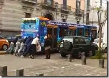 Un autobus viene spinto da alcune persone a Secondigliano