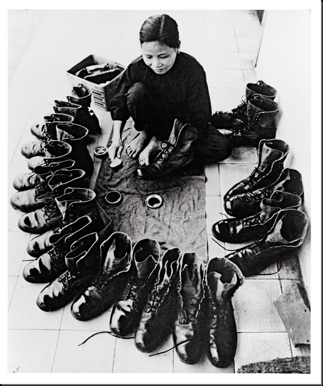 Donna Vietnamita lustrascarpe. Vietnam, circa 1973. Sembrano stivali militari statunitensi