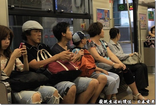 日本電車，車廂內的日本民眾幾乎是人手一隻手機，也不知道他們在看什麼內容，不過他們的手機幾乎清一色都是貝殼機。