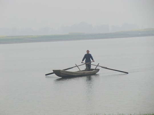 A Chinese man patrolling a lake for illegal fishing
